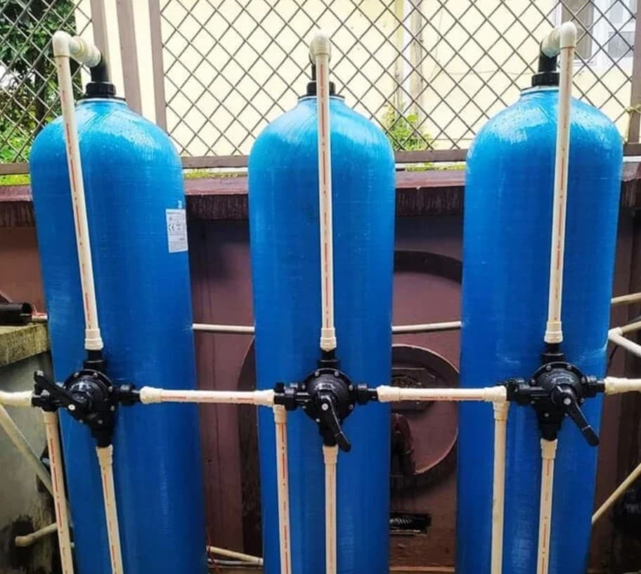 Three-stage blue FRP filter tanks with multi-port valves and PVC piping