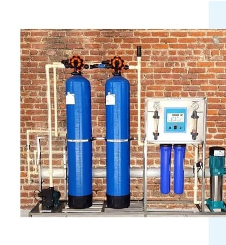 Compact three-tank FRP water filtration system with white PVC manifold
